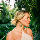 Woman in a beige dress with green foliage in the background